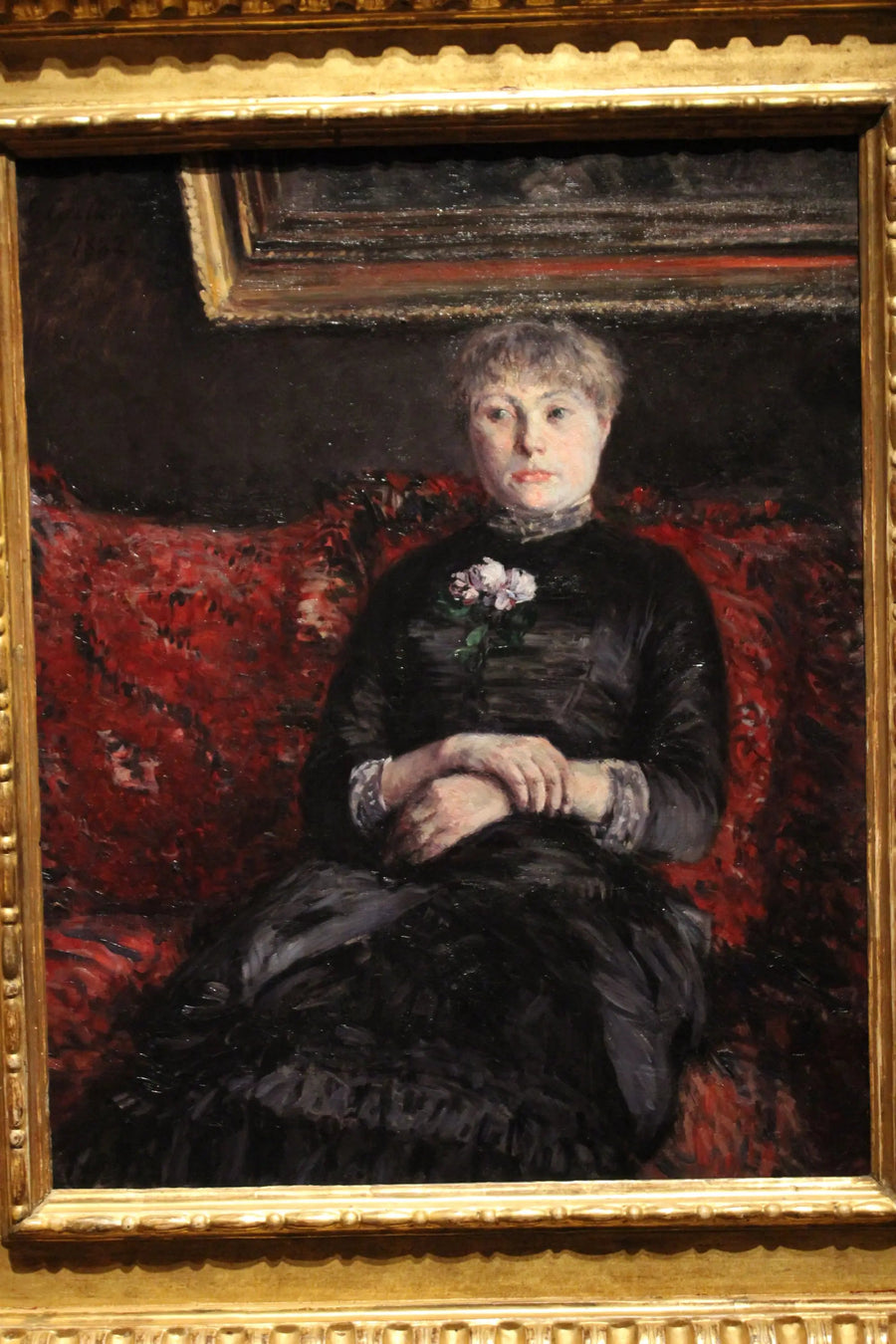 Mujer sentada en un sofá de flores rojas - Gustave Caillebotte